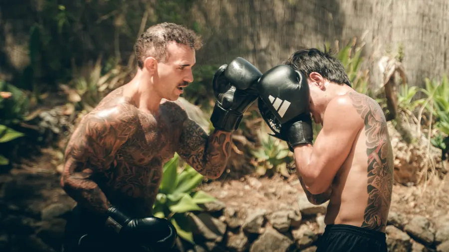 Zwei Männer mit Boxhandschuhen beim Sparring, Stirn an Stirn.
